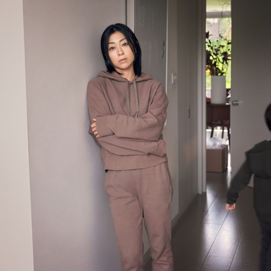 Hikaru Utada stands at home, in sweats, a child just disappearing at the edge of frame